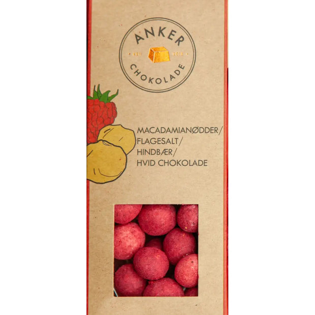 Anker Chokolade økologisk dragée 70 g med macadamianødder overtrukket med hvid chokolade, hindbærpulver og flagesalt – sprød nøddekerne og frisk bærnote, opbevares køligt