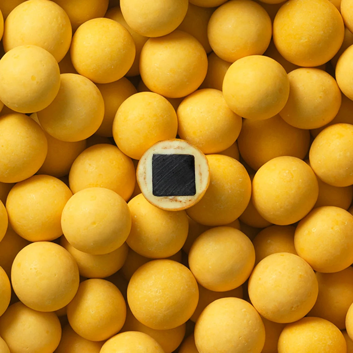 Makrofoto af Lakrids by Bülow B - Passion Fruit – lakridskugler overtrukket med hvid chokolade og passionsfrugt med knasende sukkerskal, gourmetlakrids til deling (550 g)